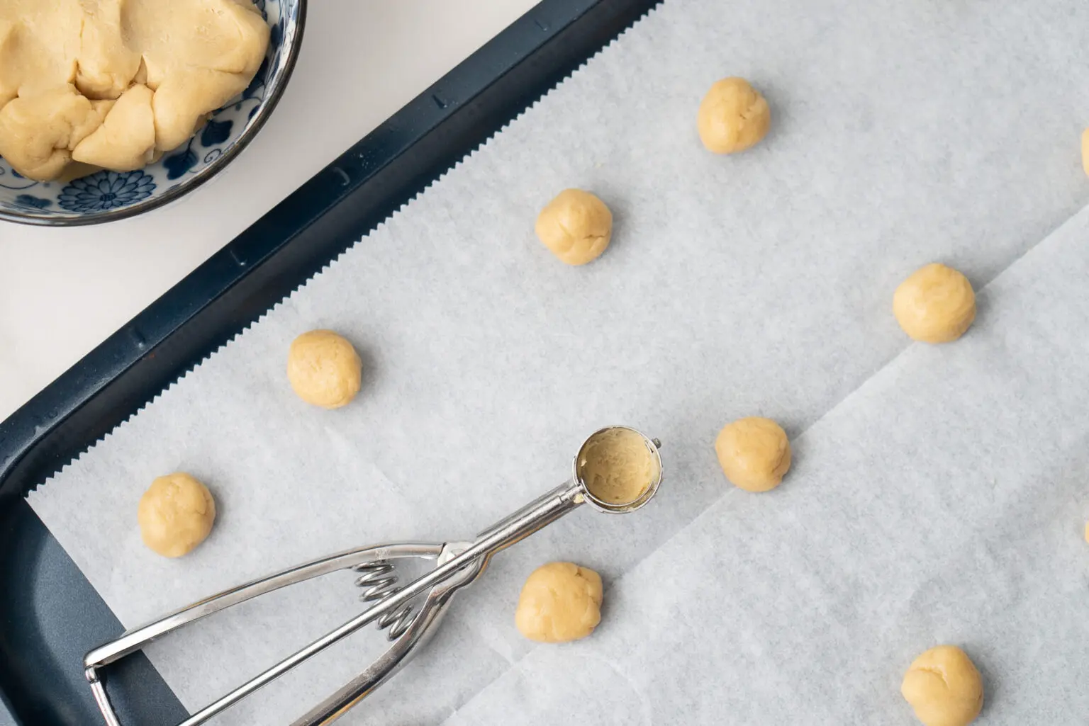 Italian Wedding Cookies Recipe on a tray with a scooper