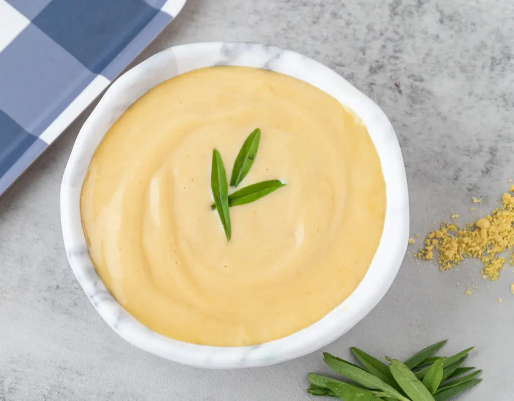 Creamy Mustard Sauce Recipe | In a bowl with a blue gingham tray and herbs