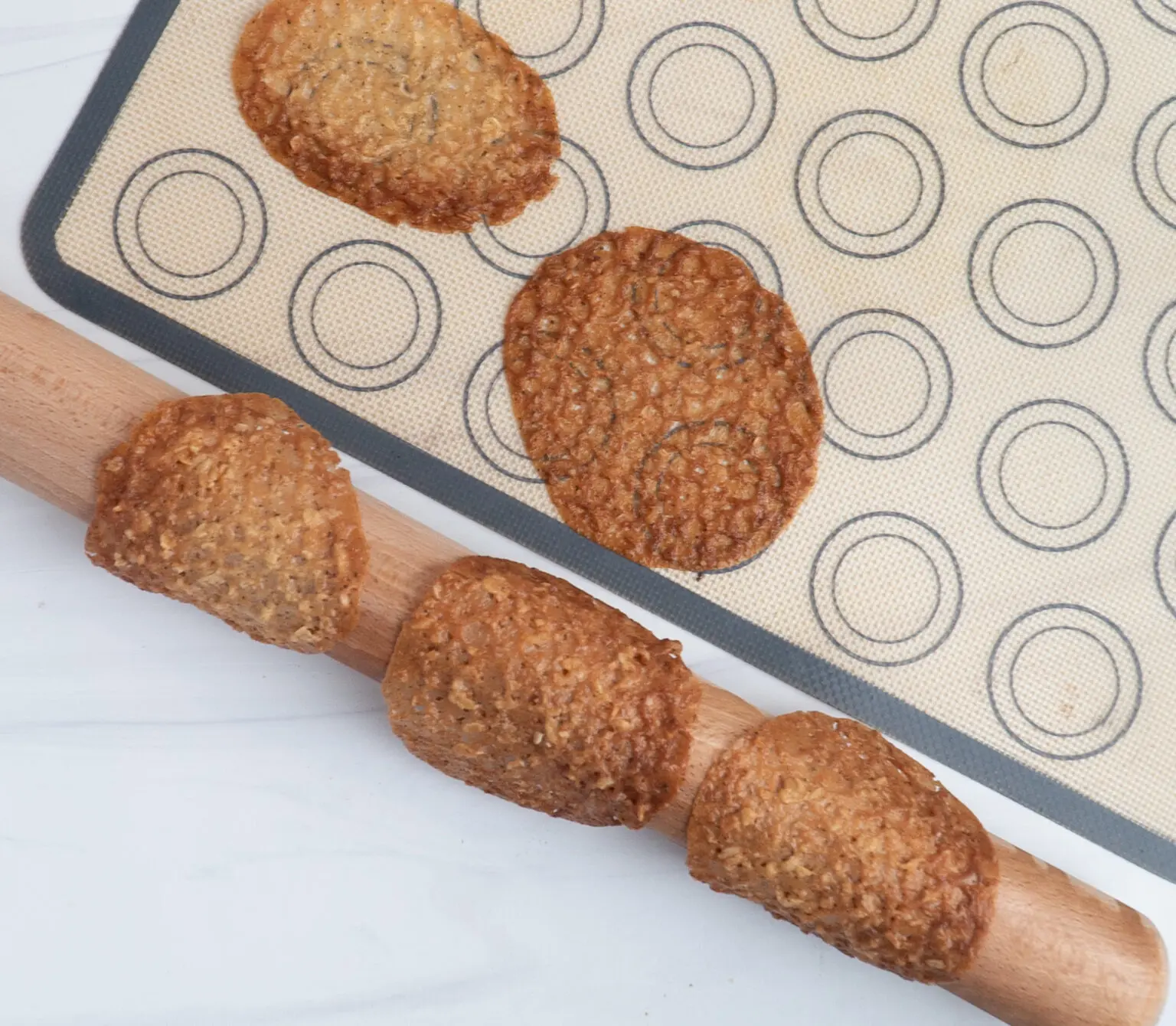 Brown Butter Irish Lace Cookies on a try and a rolling pin