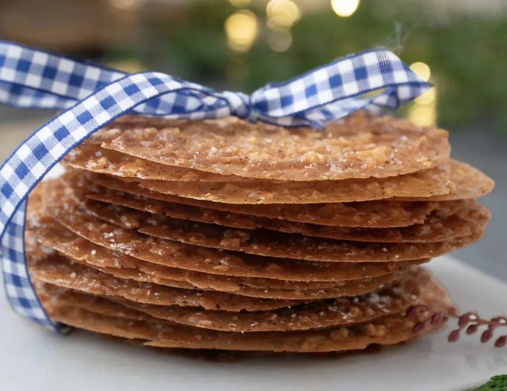 Irish Lace Cookies recipe stacked tied with a gingham ribbon