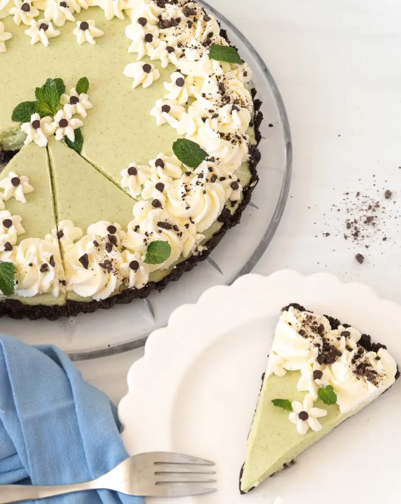 Lillian's Grasshopper Pie recipe cut slice on a plate and full pie in the background with a blue napkin.