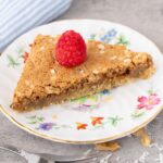 Butternut Bars on a small flowered dish with a raspberry