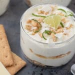 Creamy lakeside lime mousse served in small glass cups, garnished with fresh lime zest curls and a thin lime wedge.