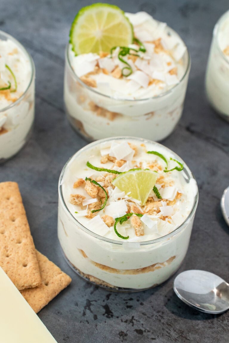 Creamy lakeside lime mousse served in small glass cups, garnished with fresh lime zest curls and a thin lime wedge.