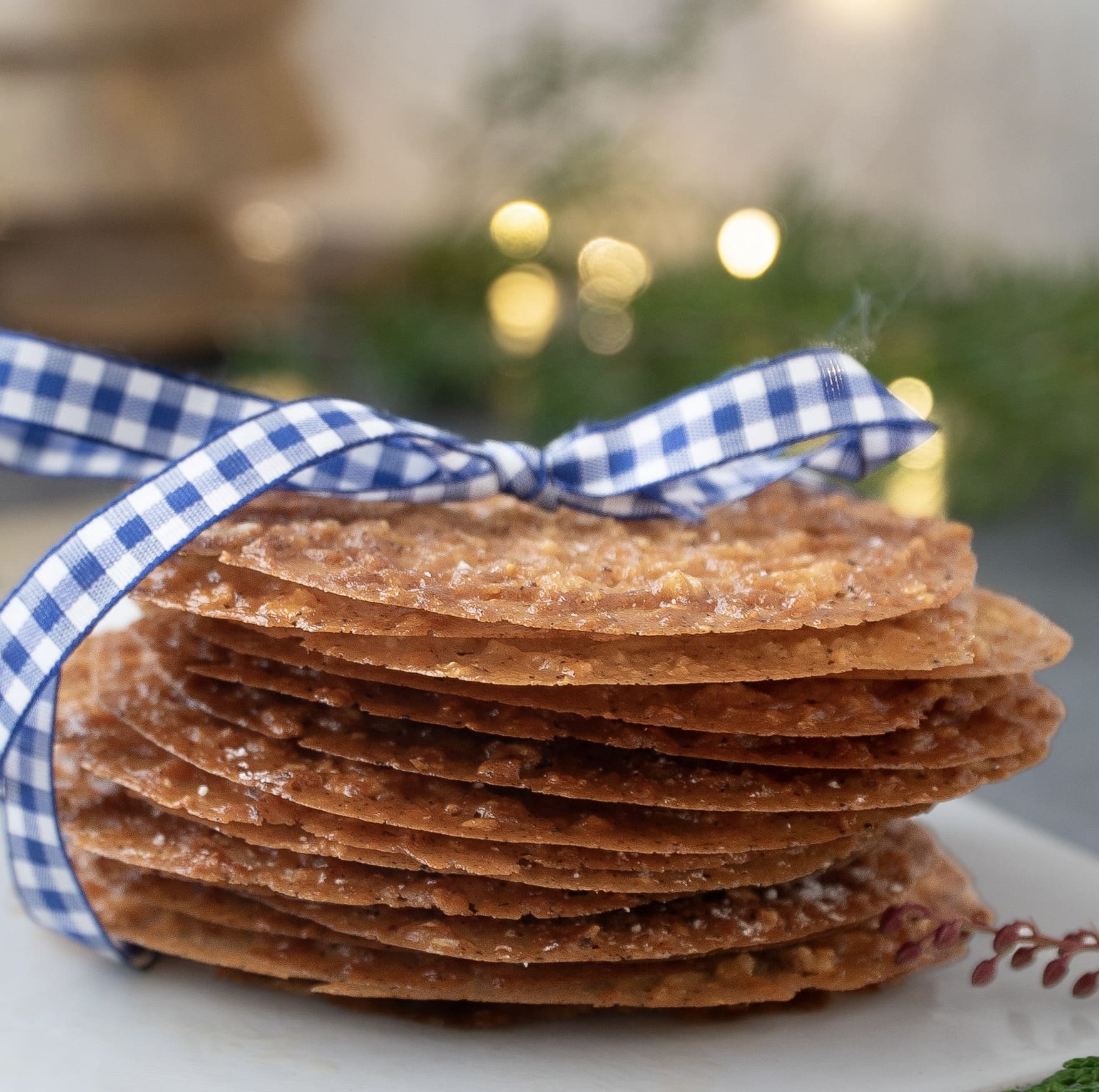 Irish Lace Cookies recipe stacked tied with a gingham ribbon