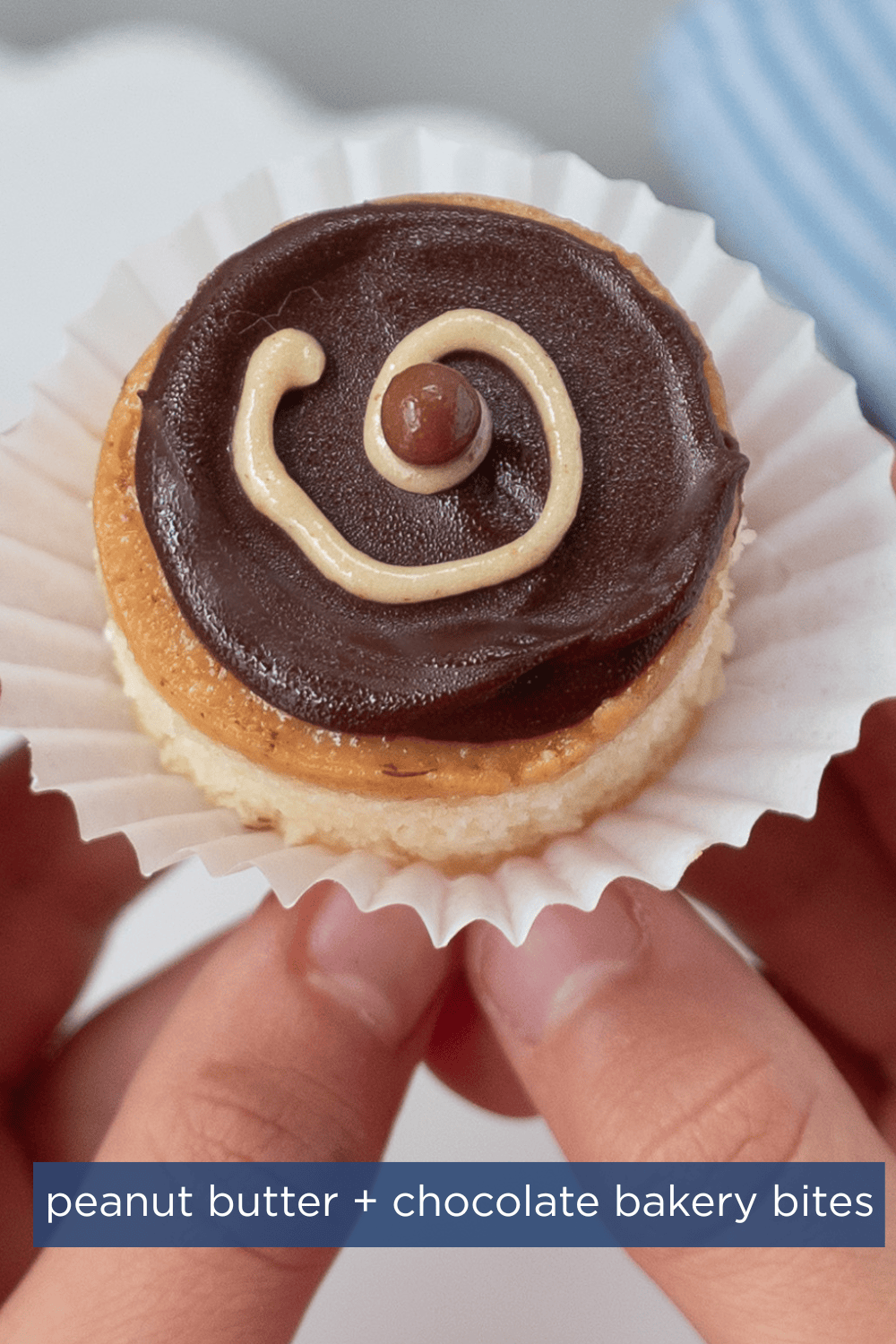kids hands holding a mini round cake bite with chocolate frosting and a swirl of peanut butter