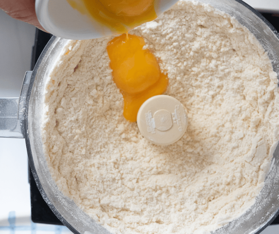 Adding egg yolks to food processor that has flour inside | Hungarian Ruffled Tart Recipe