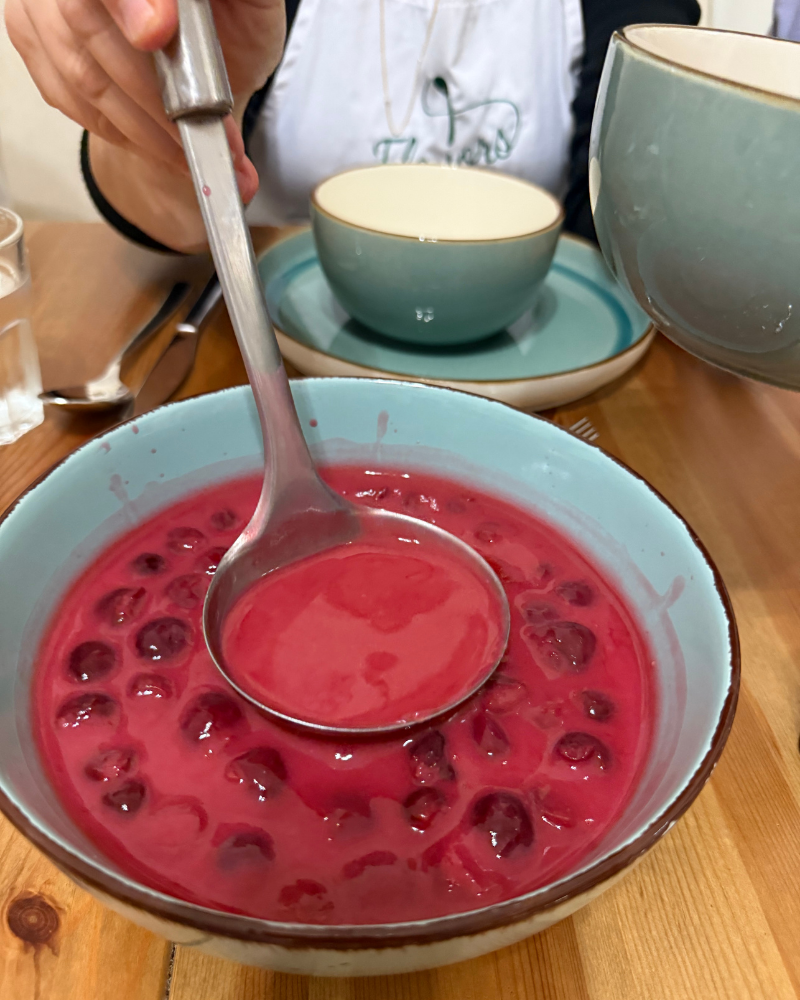 Bowl of vibrant red Hungarian sour cherry soup made with Balaton cherries, served chilled.