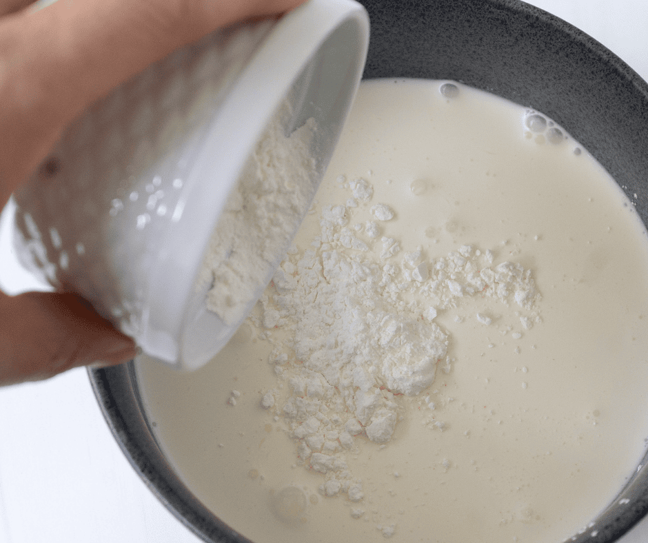 Cream in a small bowl with cornstarch being whisked in to thicken the soup.