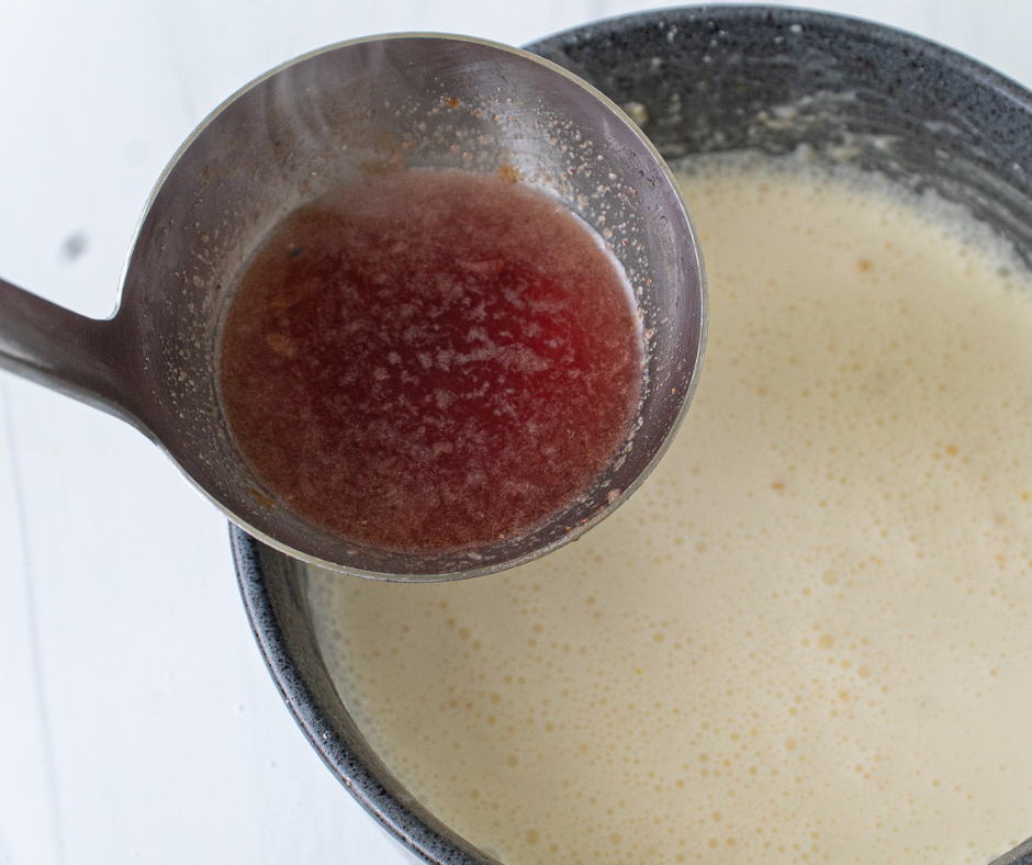 Hot cherry broth being slowly poured into cream to temper and prevent curdling.