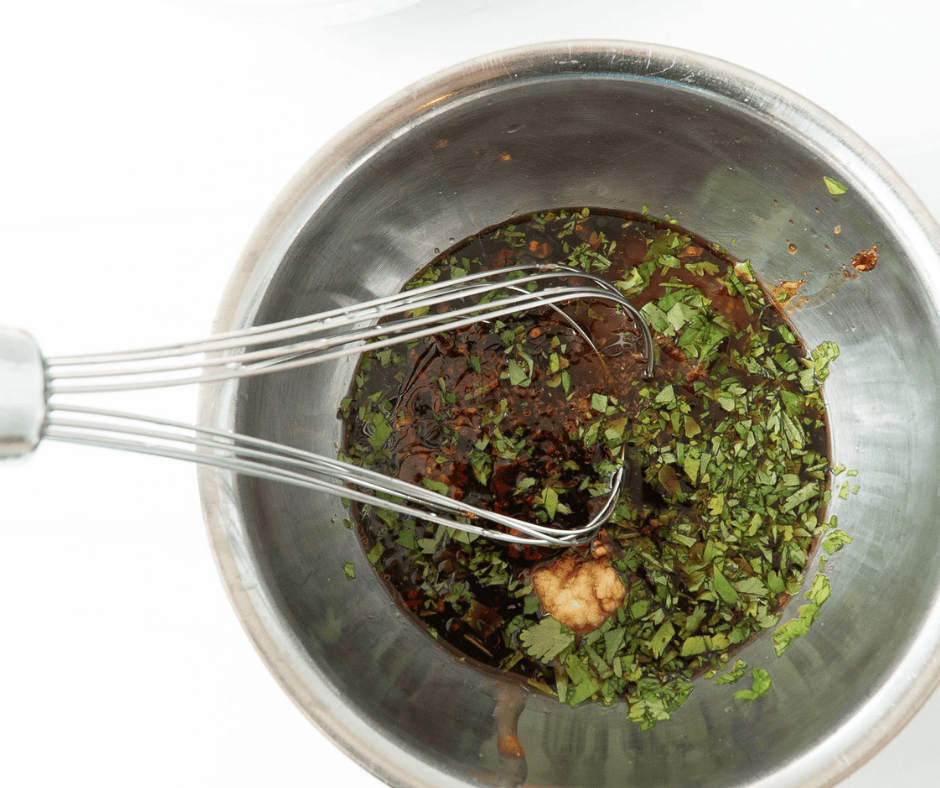 Whisk in a metal bowl with marinade ingredients for Thai salmon rice bowls
