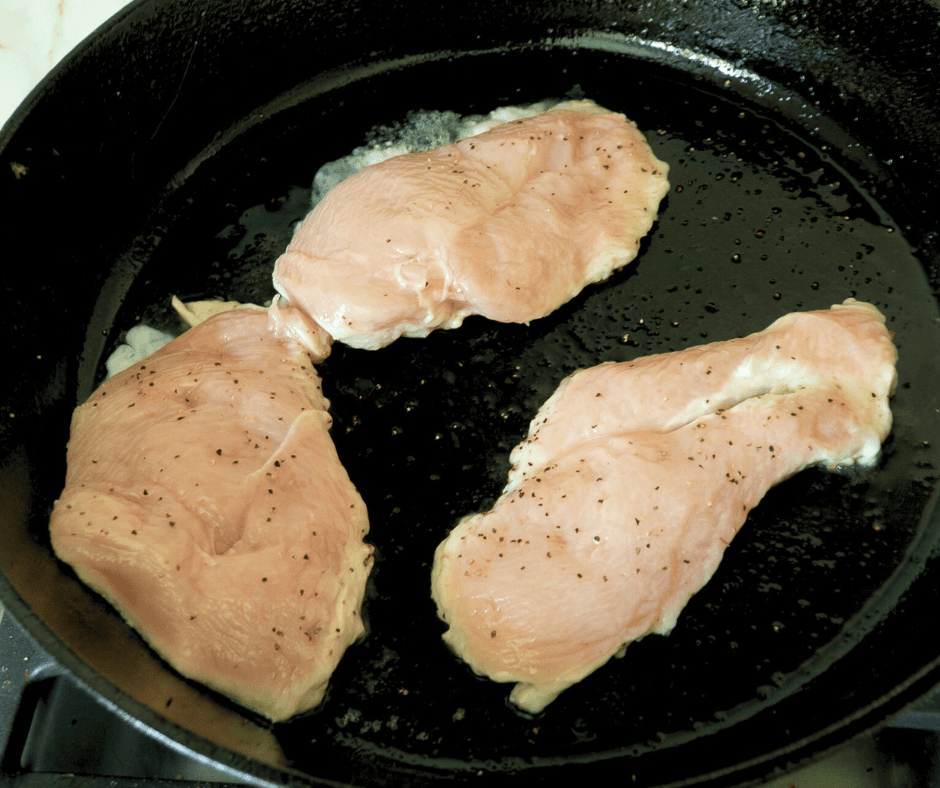 Searing chicken in a pan for Teriyaki Chicken Bento Box.
