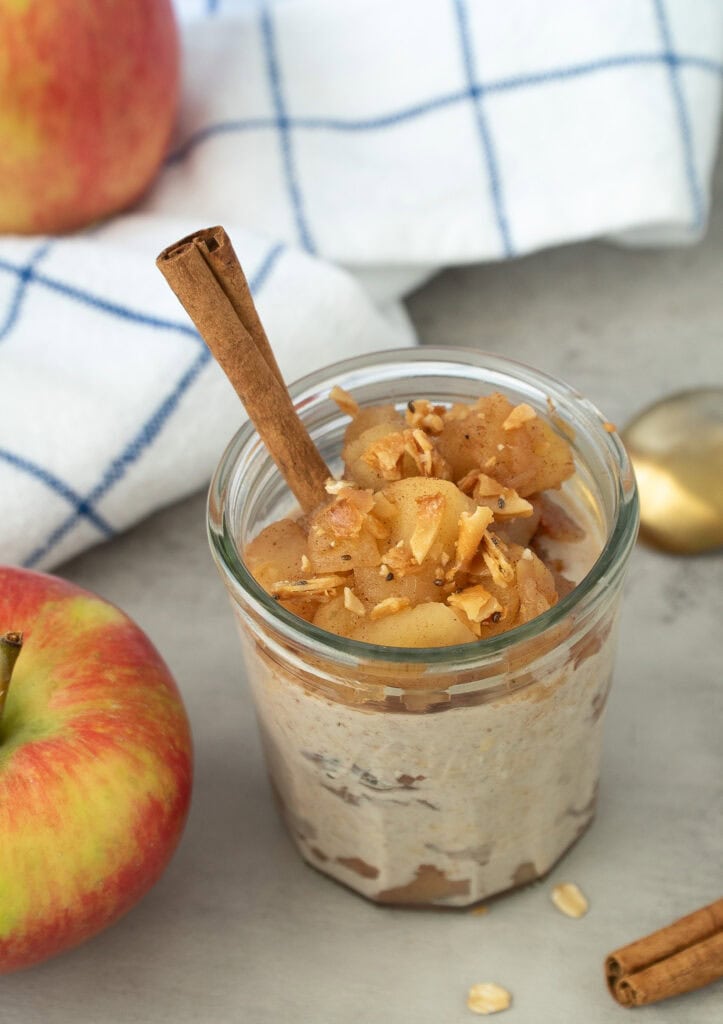 HERO SHOT Apple Pie Overnight Oats in a parfait cup with a cinnamon stick in it.