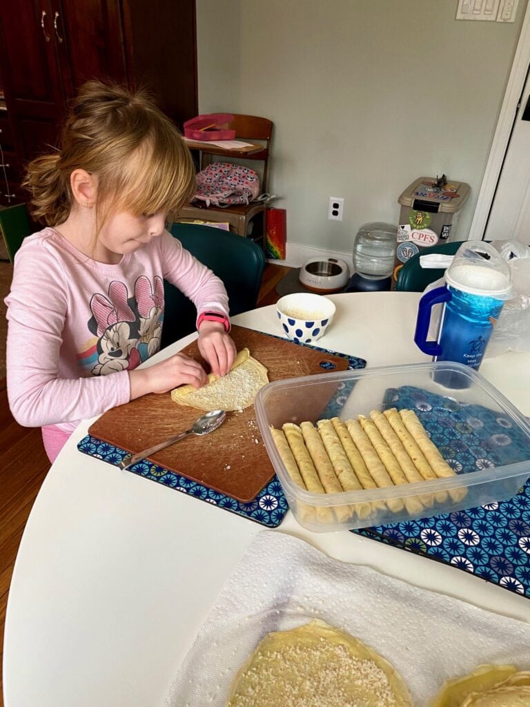 Little girl rolling scrippelle for 