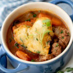 Close up shot of Beef Stew with a heart shaped Herb Dumpling in small blue cup with handles