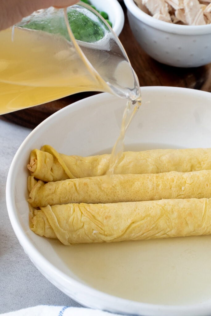 Scrippelle ‘Mbusse (Italian crepes in broth) Pouring broth over scrippelle crepes