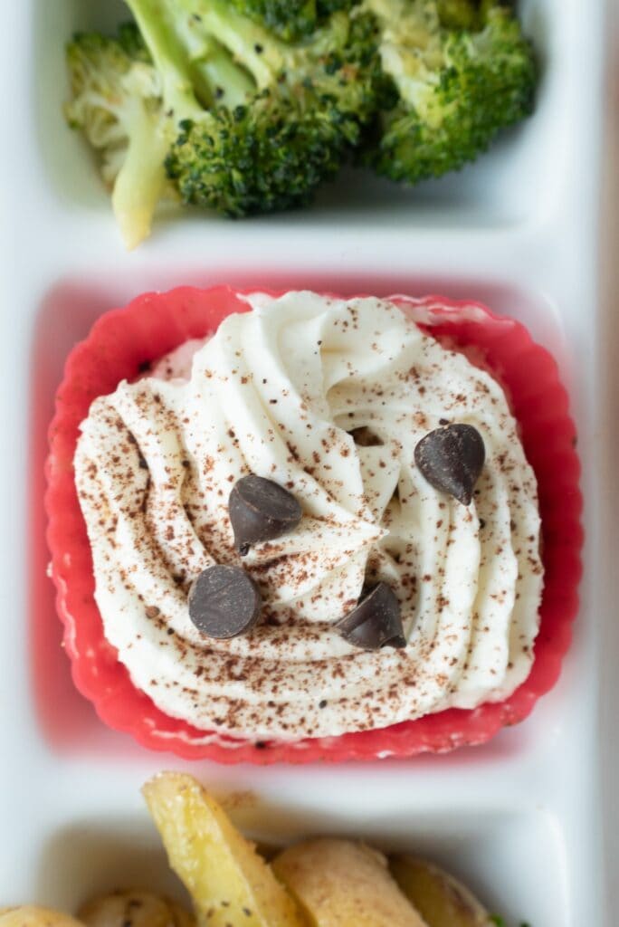 Close-up of a mini tiramisu cup with chocolate chips. 