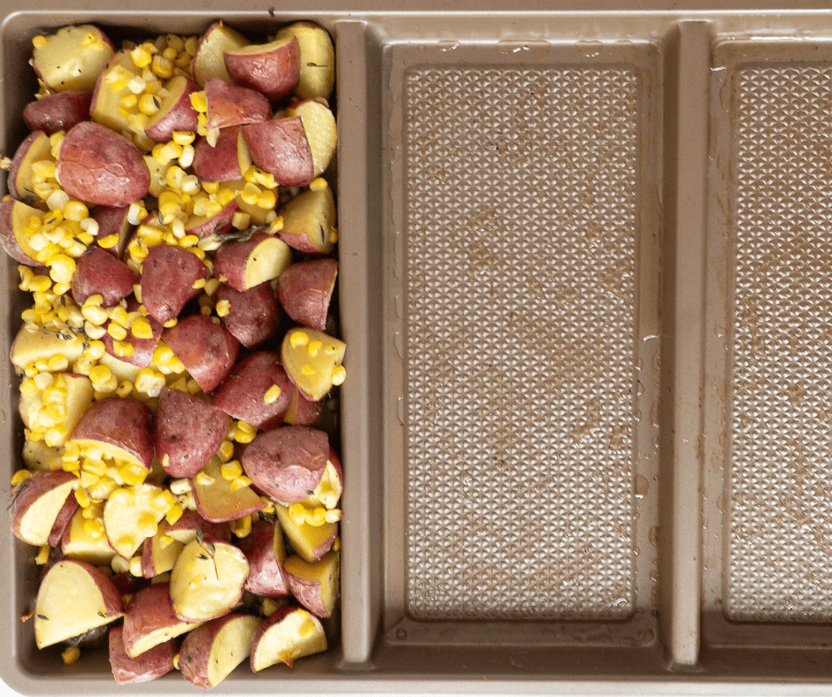 Process picture of potato and corn medley in one section of a divided pan.