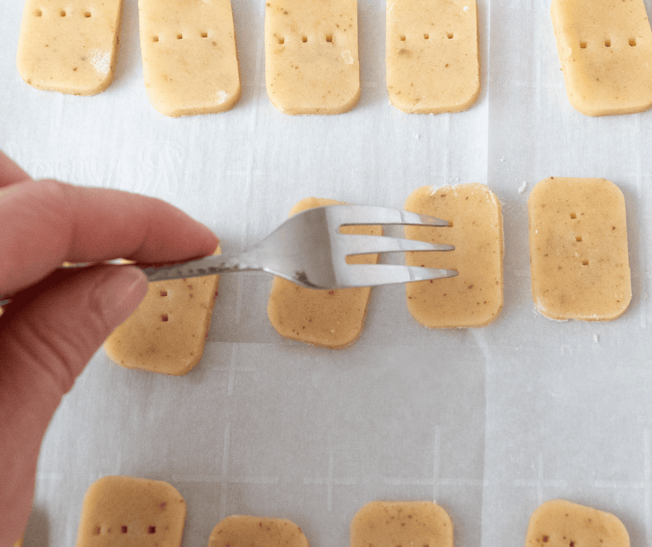 Photo of a hand holding a fork docking the rectangular dough cut outs