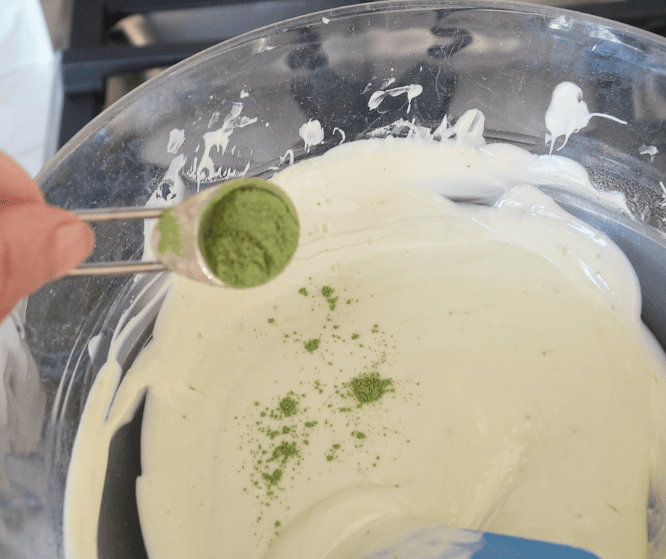 Adding a sprinkle of matcha powder to melted white chocolate. 