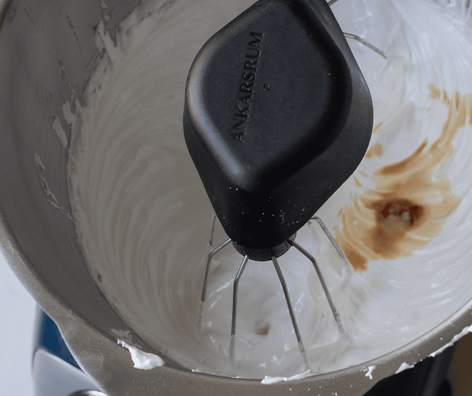Adding vanilla and almond extract to stiff meringue before spooning onto the baking sheet