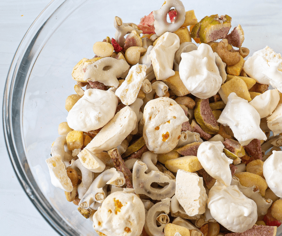 Meringue snack mix assembled in a glass bowl with vanilla-almond cloud meringues resting on top of the fruit and nut mix-ins