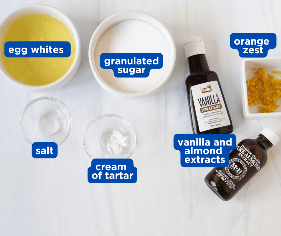 Ingredients for vanilla-almond cloud meringues including egg whites, granulated sugar, cream of tartar, vanilla and almond extracts, and orange zest